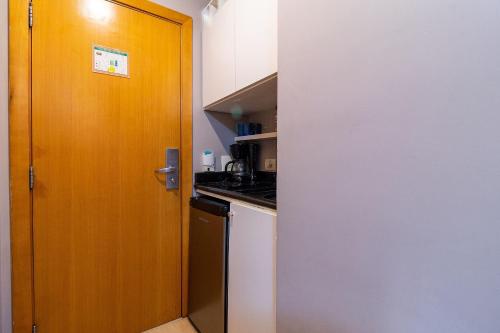 a kitchen with a wooden door next to a counter at LFlats no Hotel Stella Vega (EX-Mercury Ibirapuera) in Sao Paulo