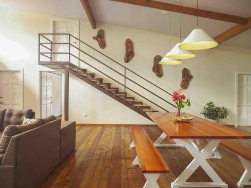 a living room with a staircase with a couch and a table at Private Villa with Pool near Manuel Antonio beach in Naranjito