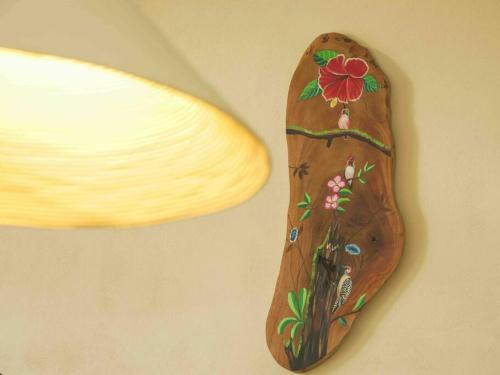 a wooden decoration on a wall with a flower on it at Private Villa with Pool near Manuel Antonio beach in Naranjito