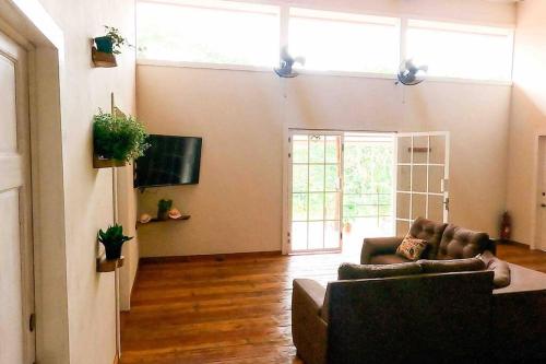 a living room with two couches and a tv at Private Villa with Pool near Manuel Antonio beach in Naranjito