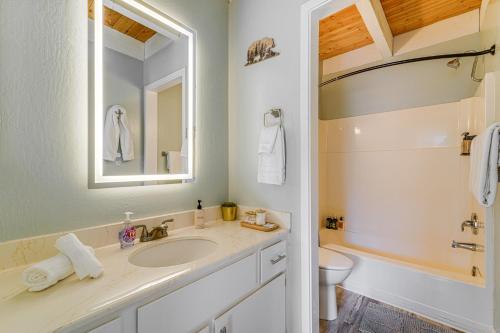a bathroom with a sink and a toilet and a mirror at 5 Mi to Northstar Bear Den Home with Decks! in Kings Beach