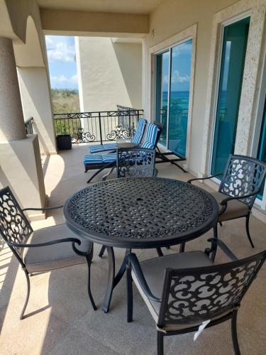 a patio with a table and chairs on a balcony at 403 Landmark Resort Cozumel beachfront condo in Cozumel