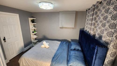 a bedroom with a blue bed with a stuffed animal on it at Private Greece inspired guest suite in Erindale in Mississauga