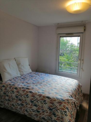 une chambre avec un lit et une fenêtre dans l'établissement Les fontaines T4 Spacieux 3 chambres parking gratuit, à Toulouse