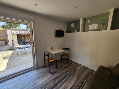 a living room with a table and a sliding glass door at Studio à louer à Villeneuve les Avignon in Villeneuve-lès-Avignon