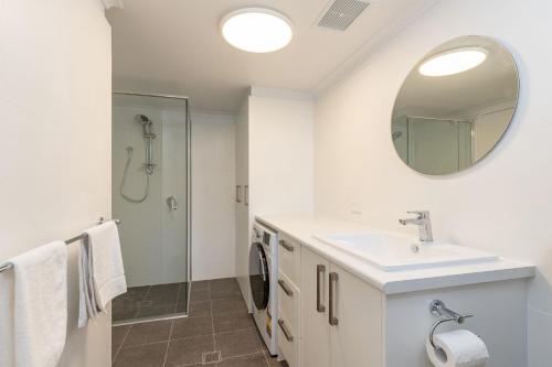 a bathroom with a sink and a mirror at Just Beachy in Boomerang Beach