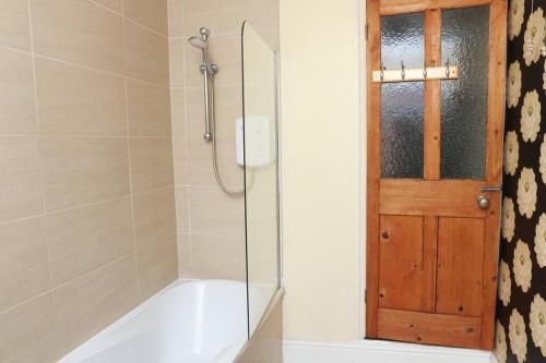 una ducha con puerta de cristal en un baño en Cosy 2 bedroom house in Leicester- entire house, sleeps 5, en Leicester