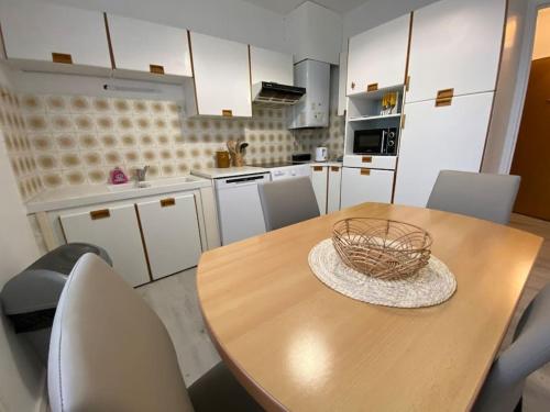 - une cuisine avec une table en bois, des chaises et un bol dans l'établissement La Douce Escale, à Carcassonne