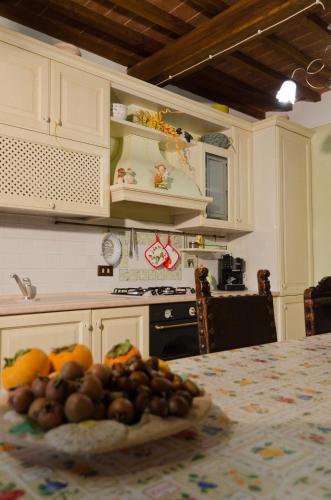 a kitchen with a table with a bowl of fruit on it at Locazione turistica ex Le Casette Di Cedromonte in Panicale