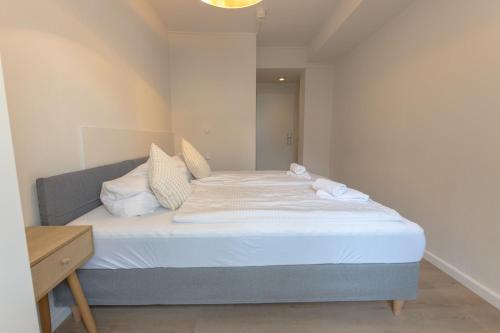 a bed with white sheets and pillows in a room at Hotel Doerenkamp - Digital Access in Düsseldorf