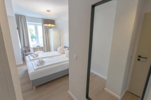 a mirror in a room with a bed and a couch at Hotel Doerenkamp - Digital Access in Düsseldorf
