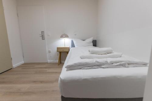 a white bed with white sheets and pillows on it at Hotel Doerenkamp - Digital Access in Düsseldorf