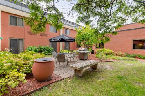 a garden with a bench and a table and an umbrella at Best Western Plus St. Paul North/Shoreview in Shoreview