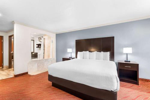 a hotel room with a large bed and a bathroom at Best Western Plus Parkway Inn in Wilsonville