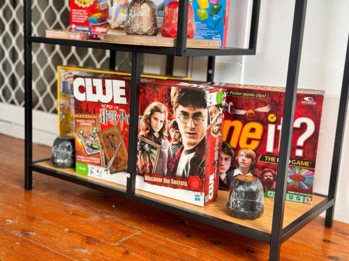 a book shelf with dvds and movies on it at Fairyland Getaway- at Central Coast with XXXL hot Jacuzzi & Fun - Round pool table and Slide bunk bed in Narara