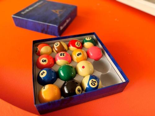 a box of billiard balls sitting on a table at Fairyland Getaway- at Central Coast with XXXL hot Jacuzzi & Fun - Round pool table and Slide bunk bed in Narara