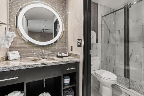 a bathroom with a sink and a toilet and a mirror at Ellis Island Hotel Casino & Brewery in Las Vegas