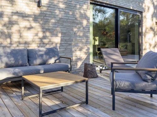 a patio with a couch and chairs on a deck at 5 star holiday home in Vestervig-By Traum in Vestervig