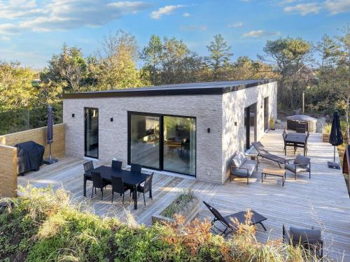 a house on a deck with a table and chairs at 5 star holiday home in Vestervig-By Traum in Vestervig