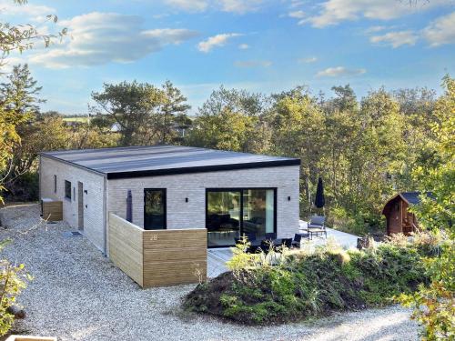 a small house with a blue roof on a gravel road at 5 star holiday home in Vestervig-By Traum in Vestervig
