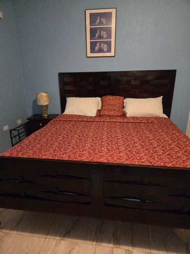 a bedroom with a large bed with a wooden headboard at Eve's Rockaway Villa in Alligator Pond Village