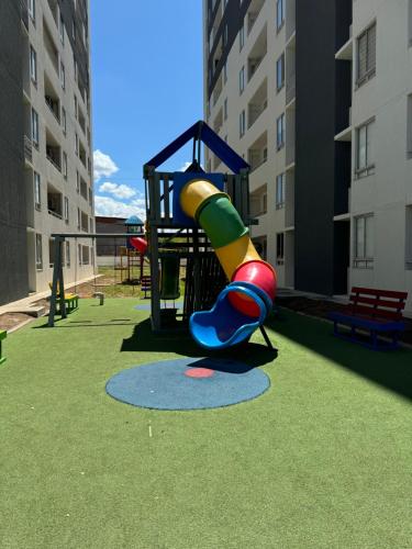 Acogedor Apartamento al oriente de Neiva في نيفا: ملعب مع زحليقة في وسط المبنى