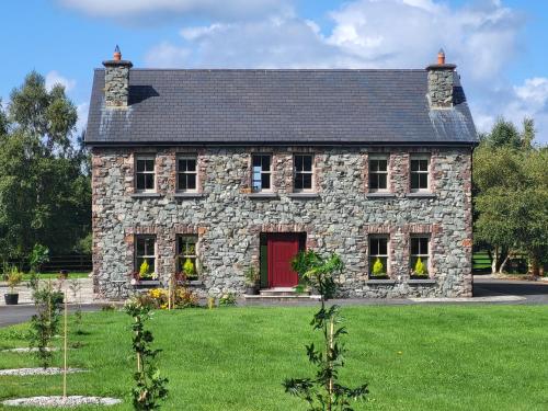 an old stone house with a red door at Reeks Country House in Killarney