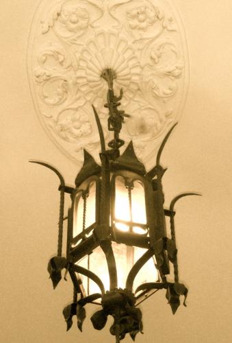 a black chandelier hanging from a wall with a carving at Sangaggio House B&B in Florence