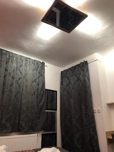 a bedroom with a ceiling light and a black curtain at Gavriel Boutique Residence Wellness Spa in Szada