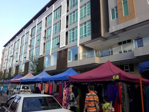 a market in front of a building with clothes on display at Nima Lodge in Kota Bharu