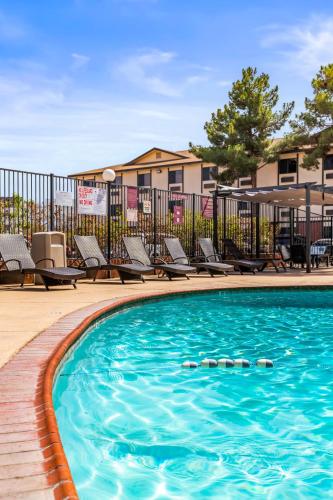a swimming pool with chaise lounges and chairs at Ellis Island Hotel Casino & Brewery in Las Vegas