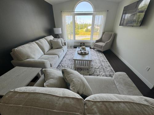 a living room with a couch and a table at Your Vivid Dwelling in Kelligrews
