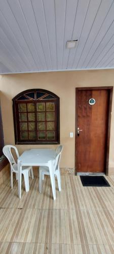a white table and chairs in a room with a door at Pousada do Arthur in Ilha do Mel