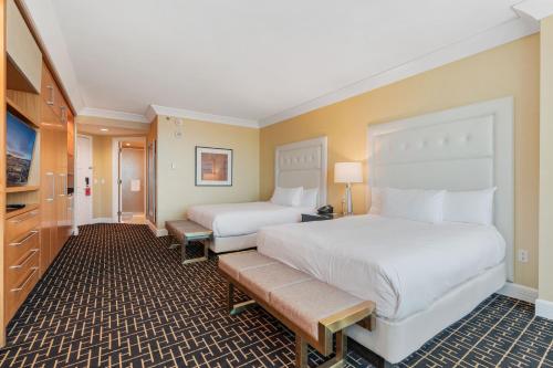 a hotel room with two beds and a television at TRUMP 56th Floor - Sphere and Strip View - No Resort Fees in Las Vegas