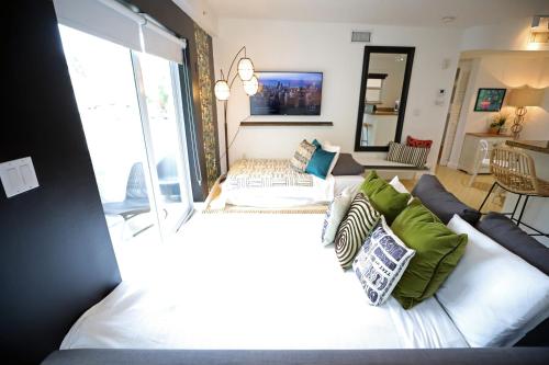 a living room with two beds and a couch at South Beach Walk to Sea Free Parking & Balcony Family & Pet Friendly in Miami Beach