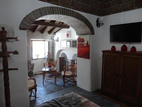 a living room with a tv and a room with a fireplace at Casa Daterra in Monsaraz