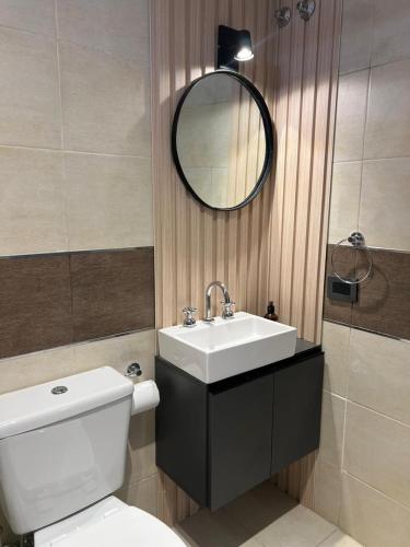 a bathroom with a sink and a toilet and a mirror at JC Apart in Córdoba