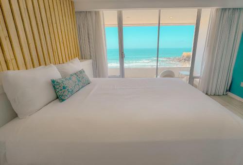 a bedroom with a bed with a view of the ocean at Castillos Del Mar in Rosarito