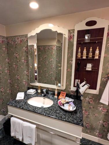 a bathroom with a sink and a mirror at Hotel IRIS -アイリス- in Osaka