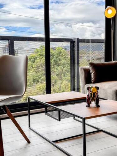 a living room with a couch and a coffee table at Skyline Suites - Elegant Living with Coworking & Scenic Views in Bogotá