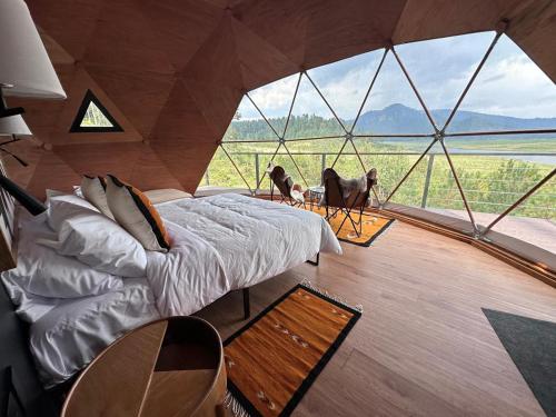 - une chambre avec un lit dans une tente avec vue dans l'établissement Lobo Glamp Corral De Pierda, à Amanalco de Becerra