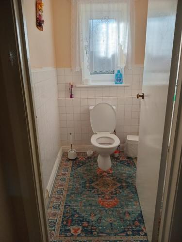 a bathroom with a toilet and a window at Wallington Homes in Carshalton