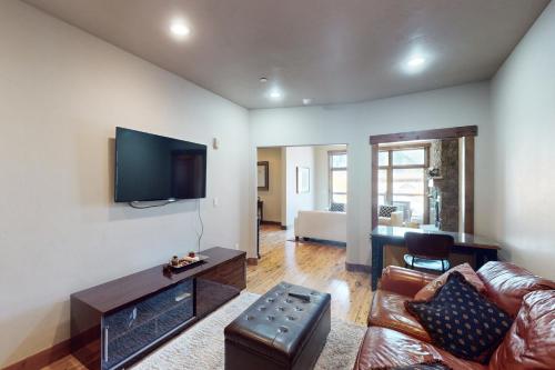 a living room with a couch and a flat screen tv at Bears Den Condo Unit 1 in Frisco