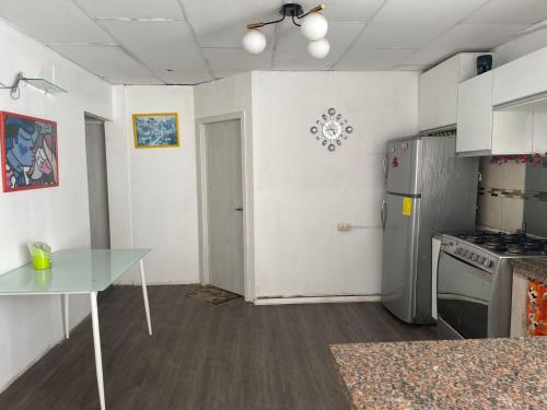 a kitchen with a glass table and a refrigerator at CÓMODA HABITACIÓN CENTRAL in Machala