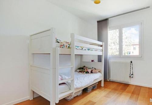 Ce lit superposé blanc se trouve dans une chambre blanche. dans l'établissement Maison familiale avec parking proche Paris et Parc des expositions de Villepinte, à Montreuil