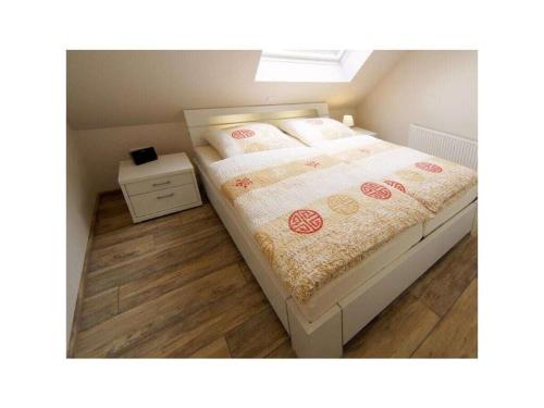 a bedroom with a bed with a wooden floor at Holiday apartment Roringstek in Norddeich