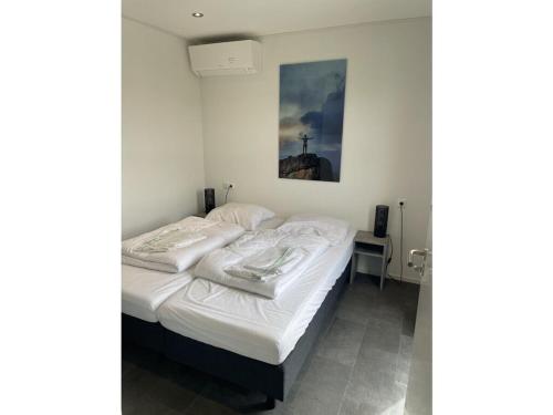 una camera da letto con un letto con lenzuola bianche di Chalet in Enkhuizen with Swimming Pool a Enkhuizen