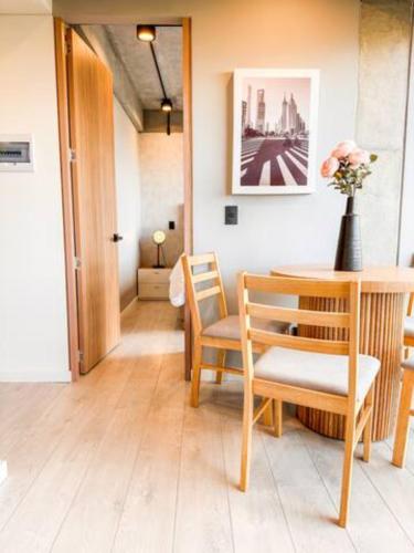 a room with a table and chairs and a vase with flowers at Skyline Suites - Elegant Living with Coworking & Scenic Views in Bogotá