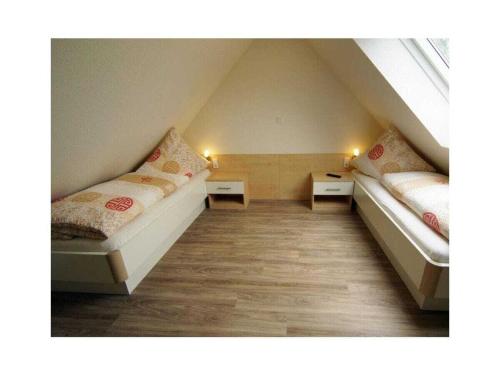a room with two beds in a attic at Holiday apartment Kettenstek in Norddeich