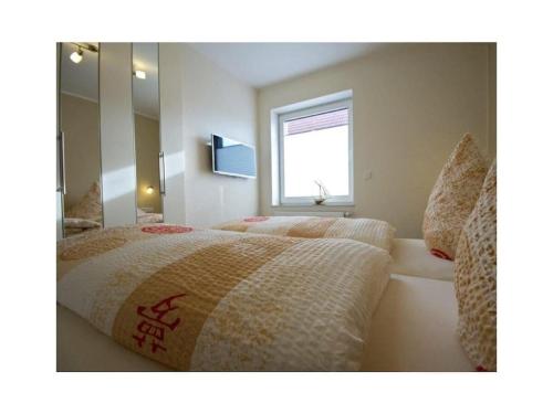 a bedroom with two beds and a mirror at Holiday apartment Ankerstek in Norddeich